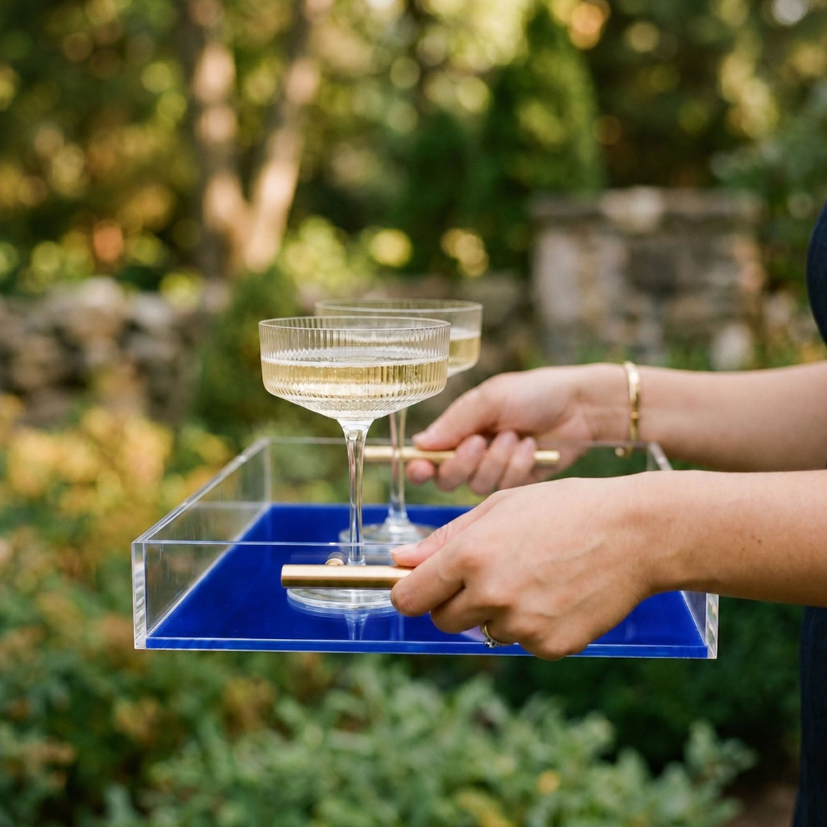 woman using custom college football acrylic serving tray with 2 drinks