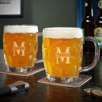 Two glass beer mugs with foam on coasters, “Miller” logo, on a table with bottles and opener nearby.
